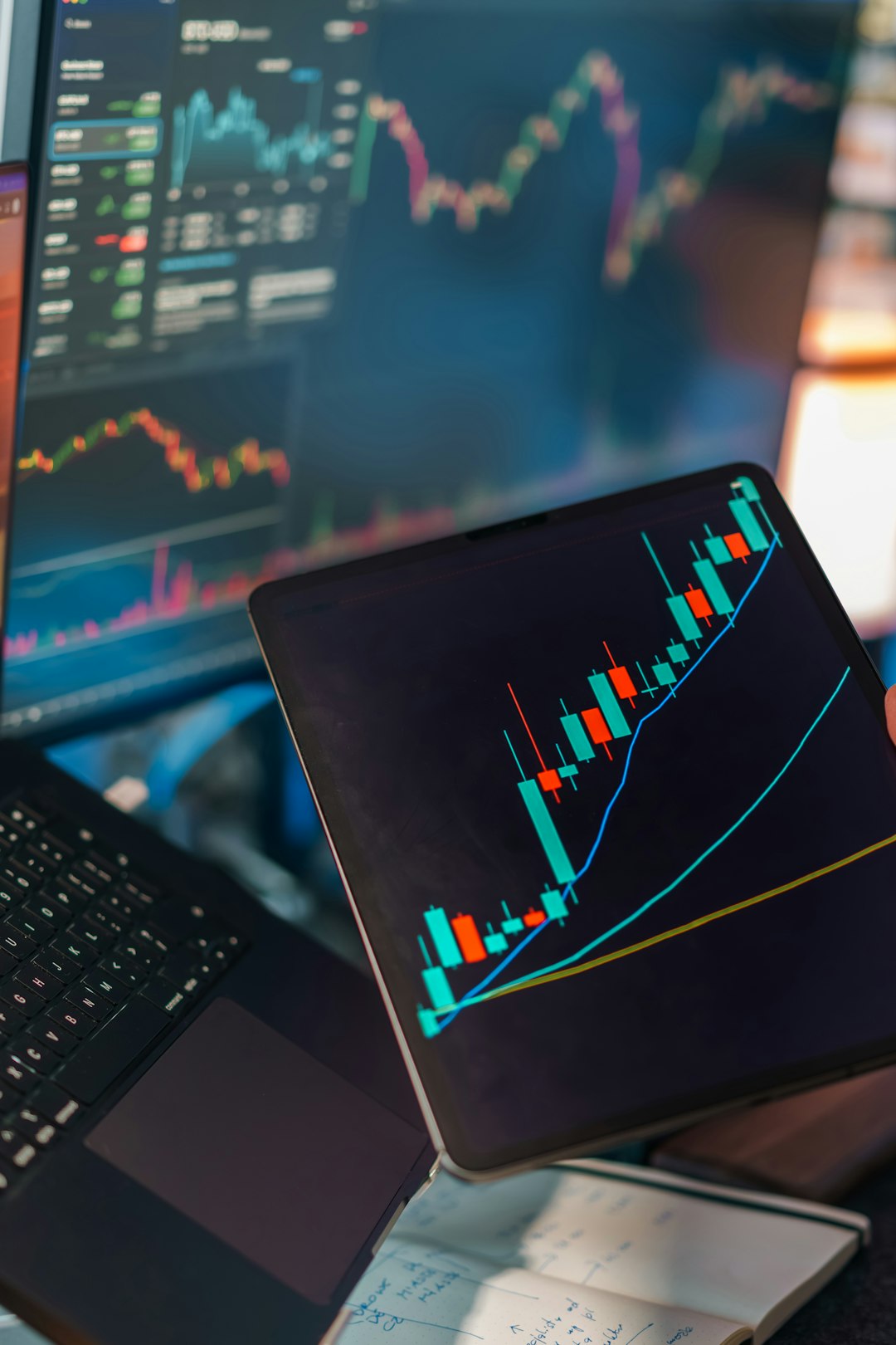 Financial trading analytics candlestick chart laptop tablet. Digital market analysis workspace showing price movement graphs technical indicators data visualization screens investment finance concept editorial business technology